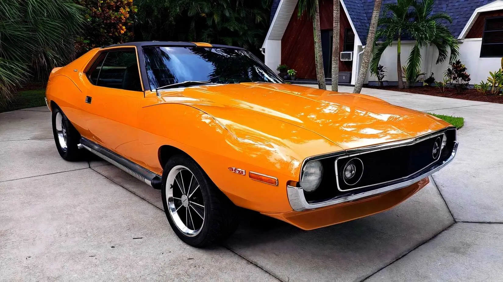 A rear three-quarter view of the same blue 1971 AMC Javelin AMX 401, emphasizing the wide rear haunches, rear spoiler, and clean design lines.
