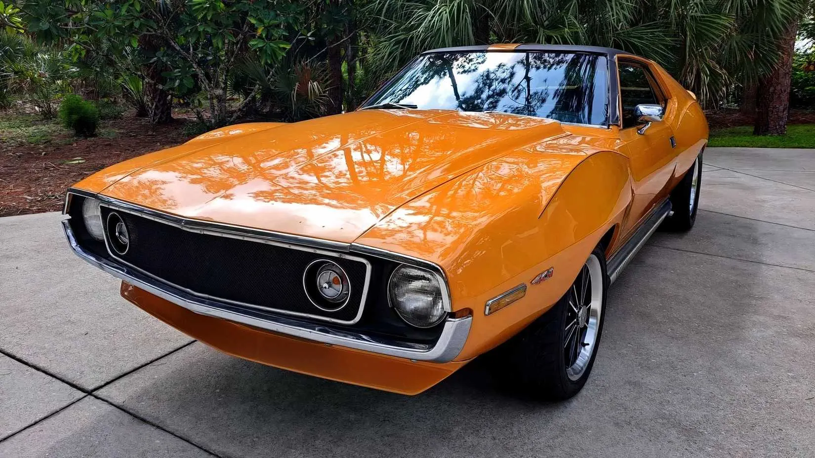 A front-angle shot of the 1971 AMC Javelin AMX 401, showing the unique front grille, bulging hood scoop, and iconic 'bullseye' fender badge.