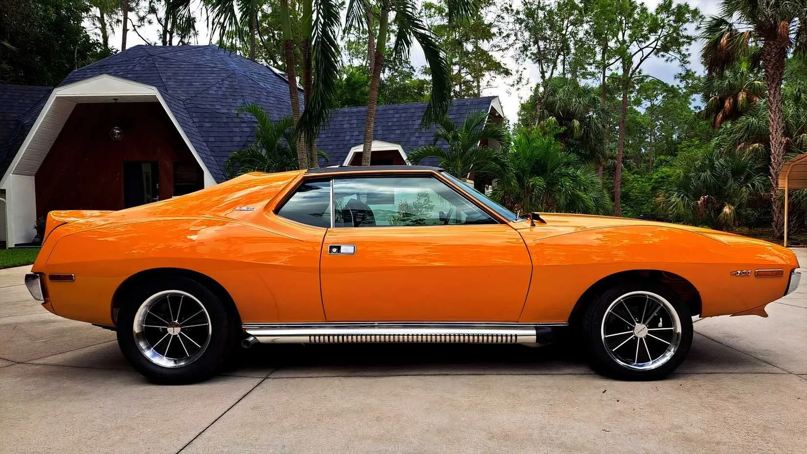 A detail shot of the 1971 AMC Javelin AMX 401 cockpit, showcasing the woodgrain dashboard, four-speed Hurst shifter, and deeply contoured bucket seats.