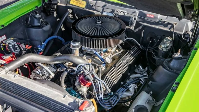 The green engine bay of a 1972 AMC Gremlin X showing the massive 304 V8 stuffed inside