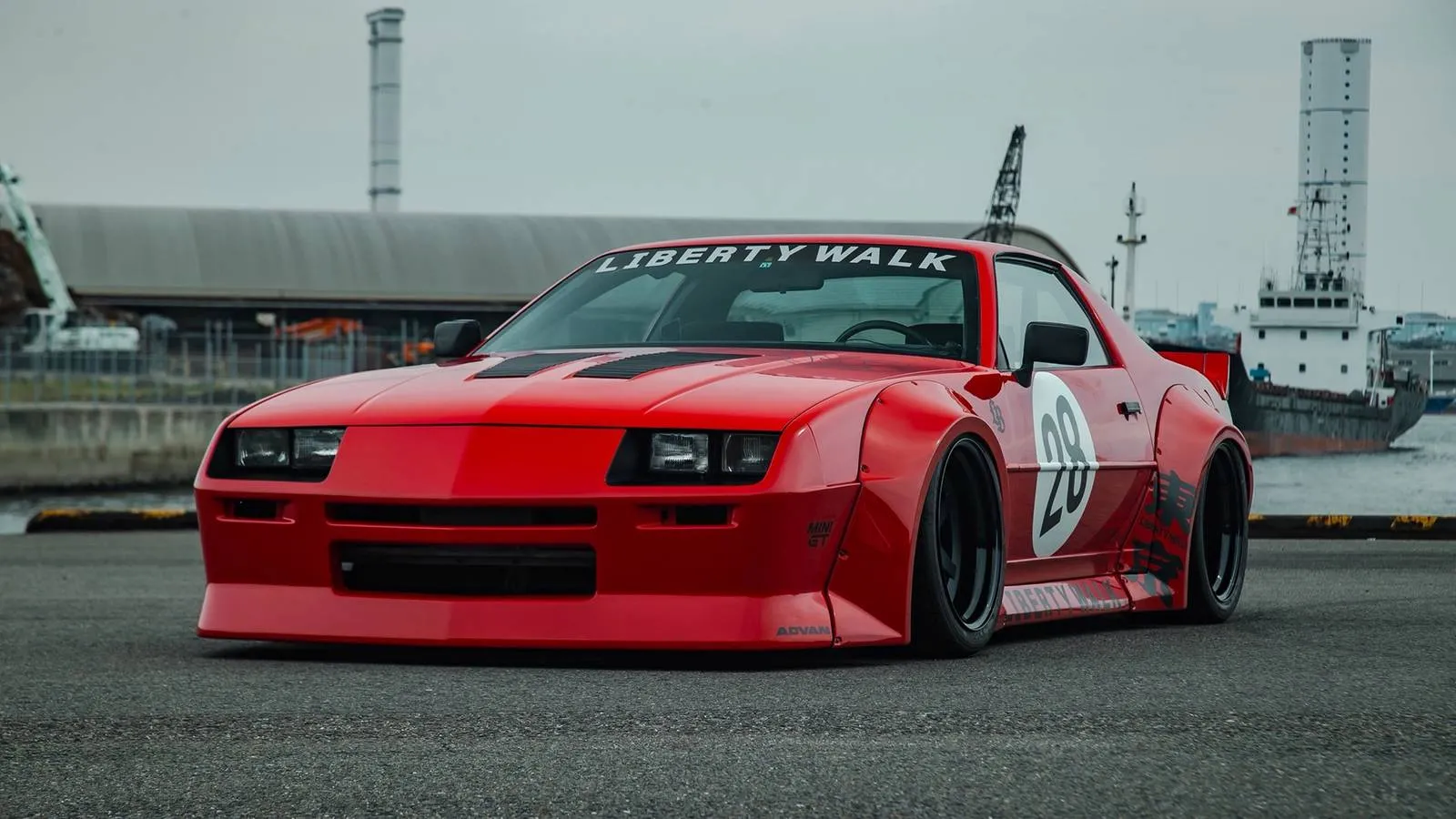 Front three-quarter view of a lowered, widebody third-gen Camaro with Liberty Walk body kit at SEMA