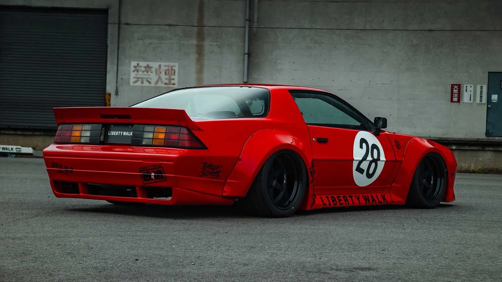 Rear three-quarter view highlighting the rear diffuser, wing, and wide arches