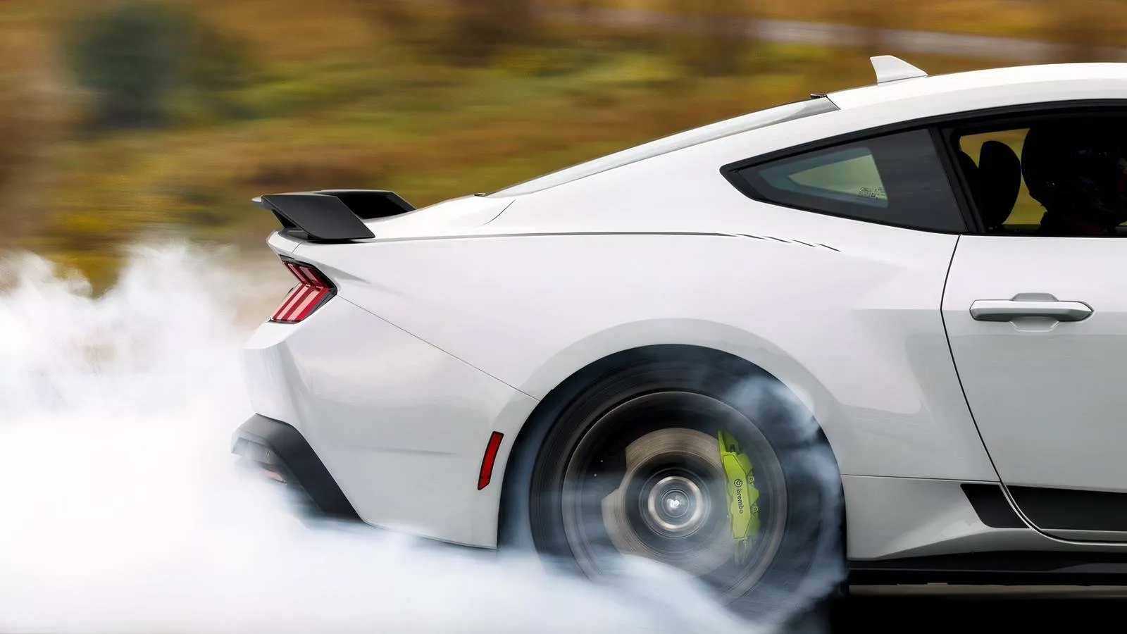 A side profile of the 2026 Ford Mustang RTR in a vibrant color showing its aggressive stance, tarnished dark wheels, and Hyper Lime brake calipers.