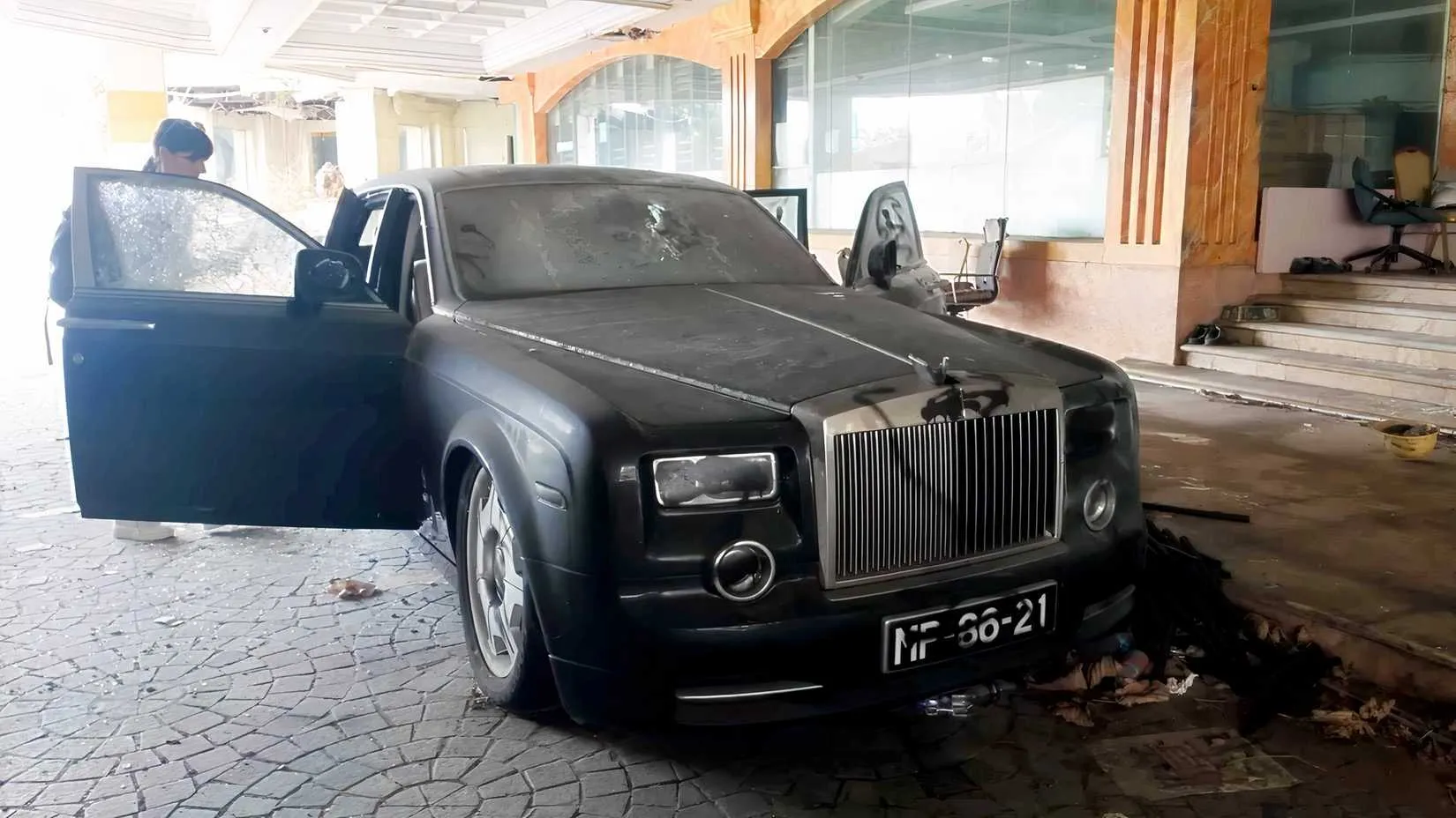 Close-up of a Phantom's shattered window and defaced paintwork, a portrait of neglect.
