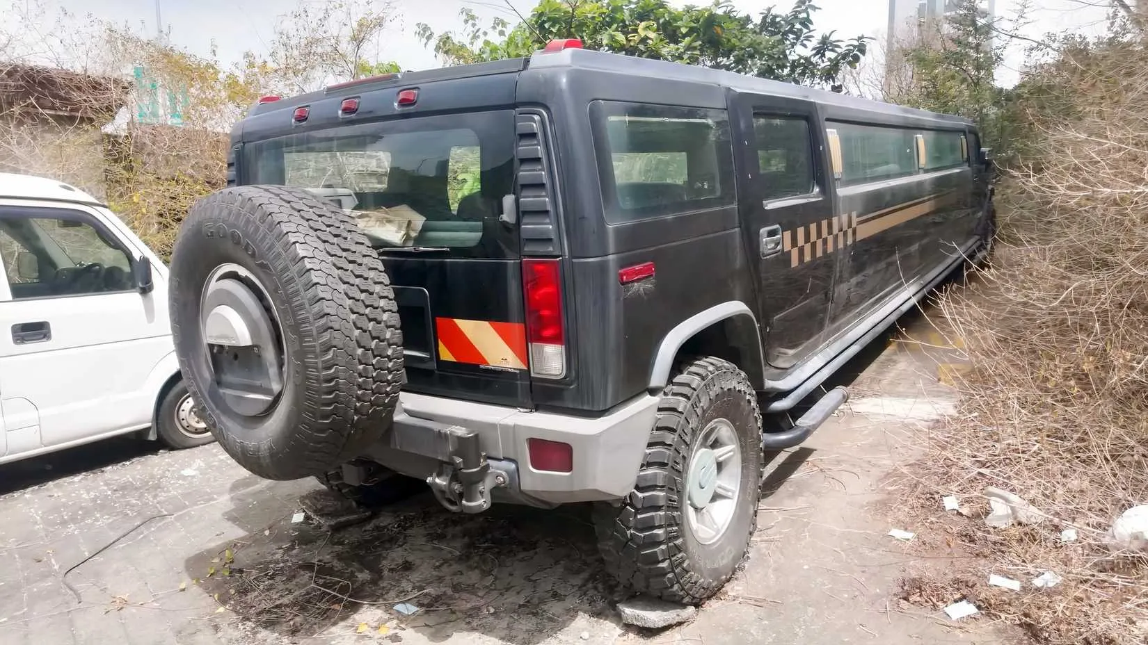 The abandoned Hummer H2 stretch limousine, its hulking silhouette a relic of bygone extravagance.