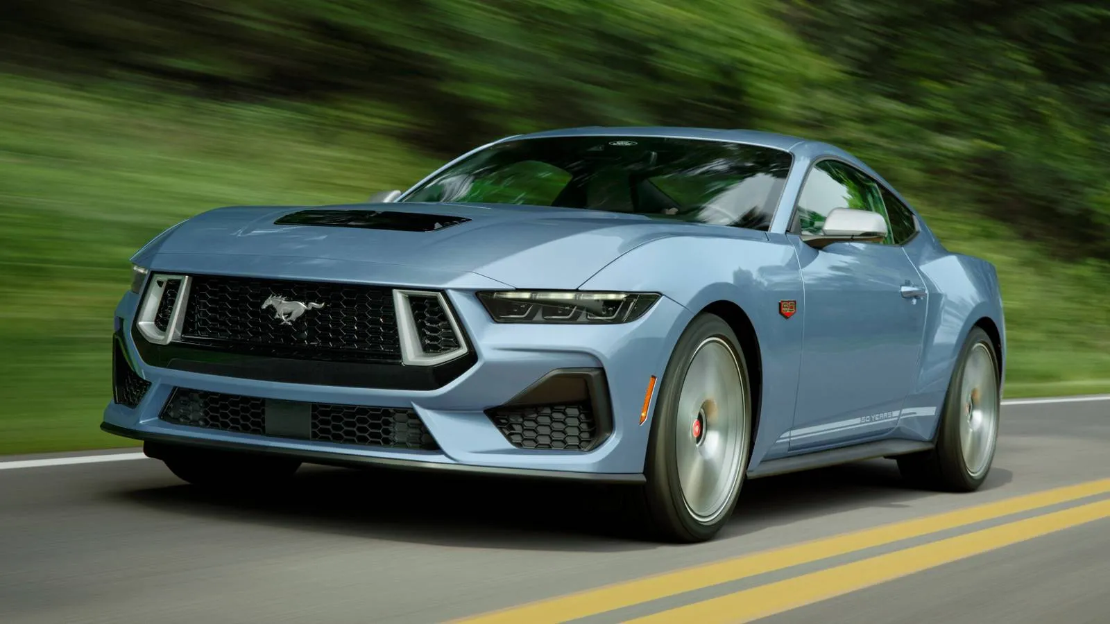 Blue 2025 Mustang GT 60th Anniversary edition parked on a coastal road