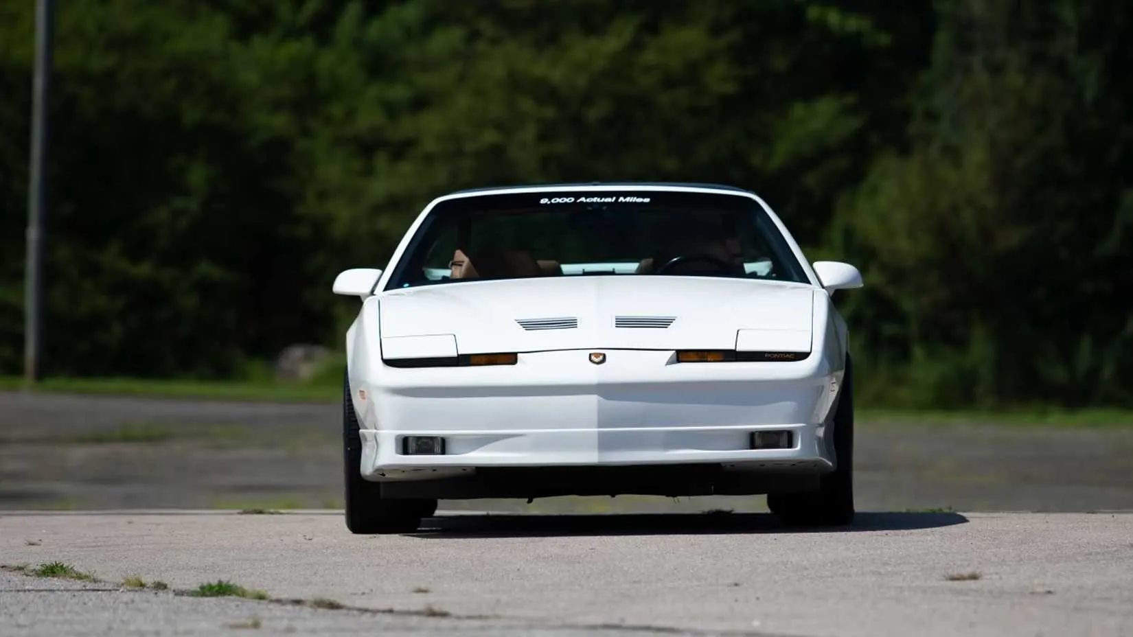 front shot of a white 1989 Pontiac Turbo Trans Am 20th Anniversary parked showing pace car decals