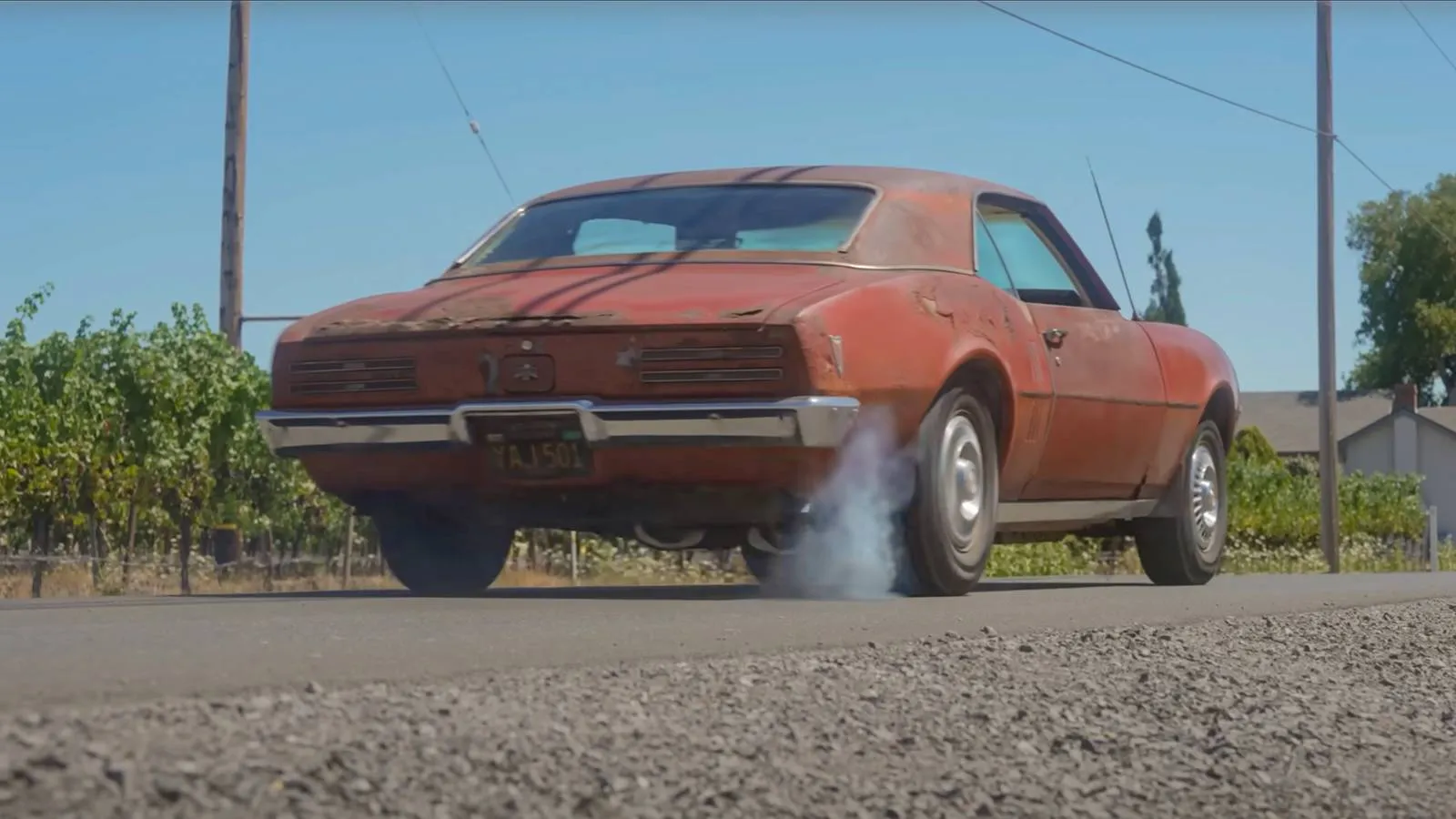 A weathered 1968 Pontiac Firebird sitting in a back lot, covered in decades of dirt and rust