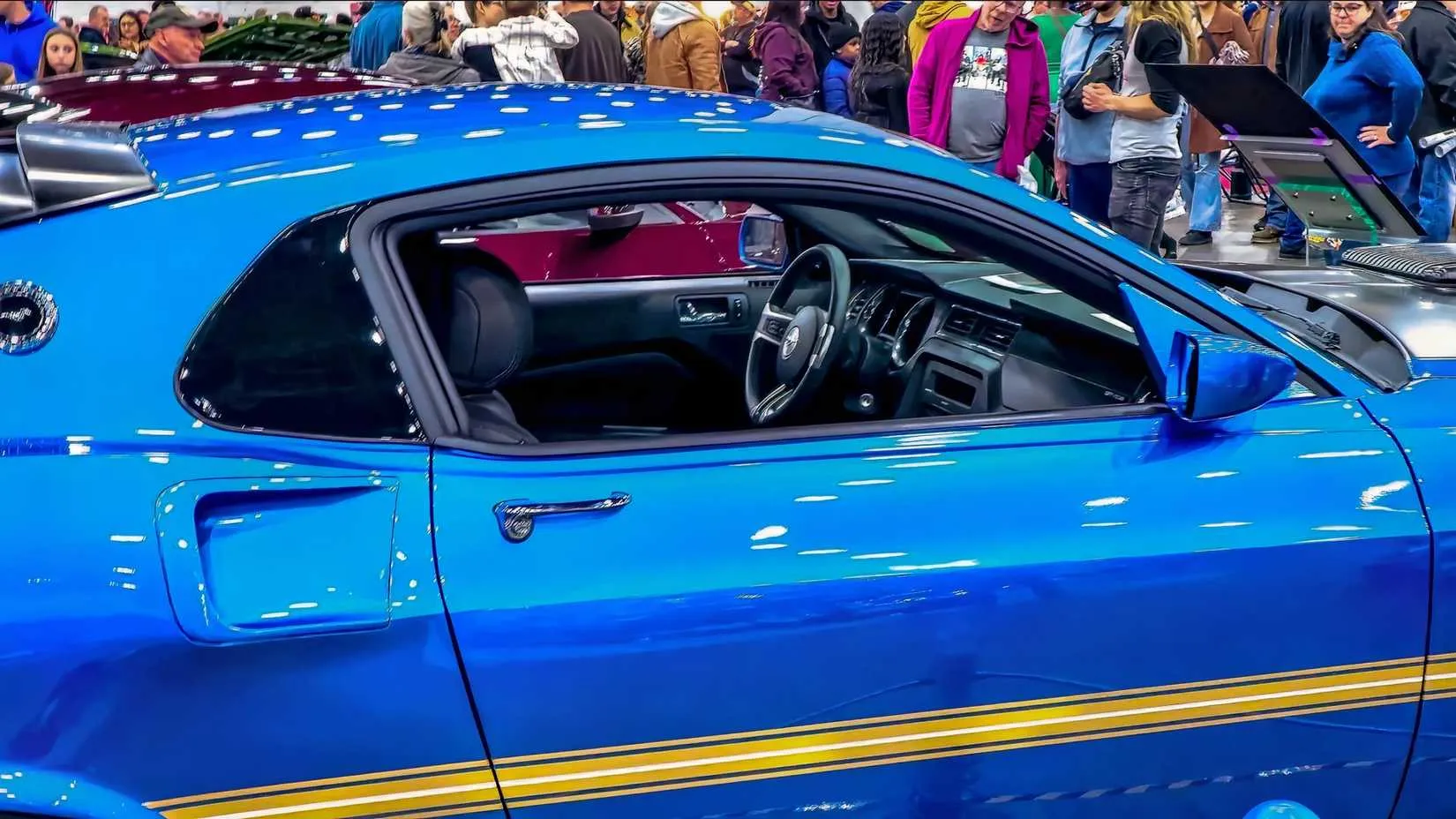 The rear three-quarter view highlighting the custom tail panel, rear louvers, and iconic Mach 1-inspired stripes