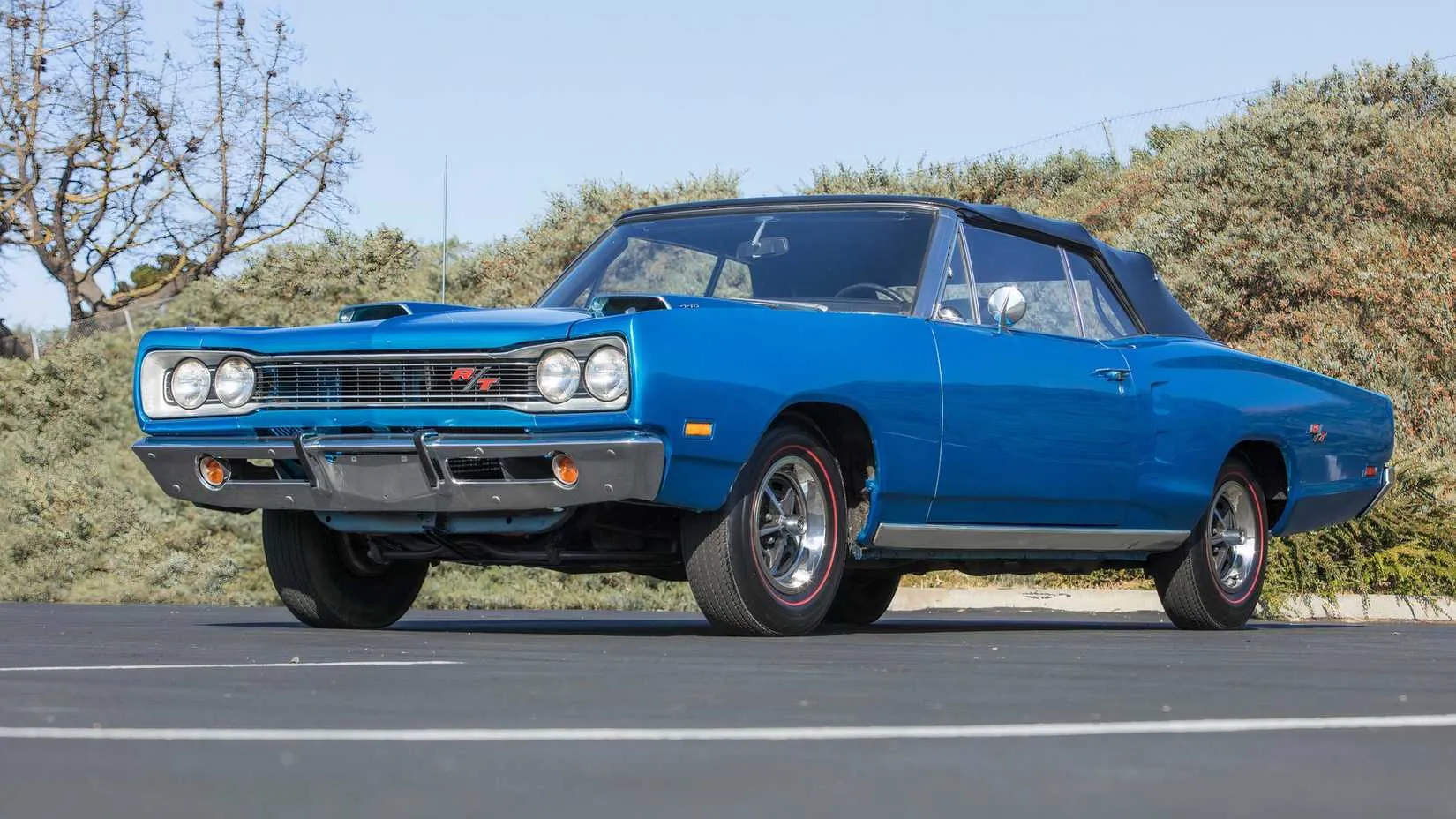 A classic 1969 Dodge Coronet R/T in burnt orange with a black hood and vintage styling
