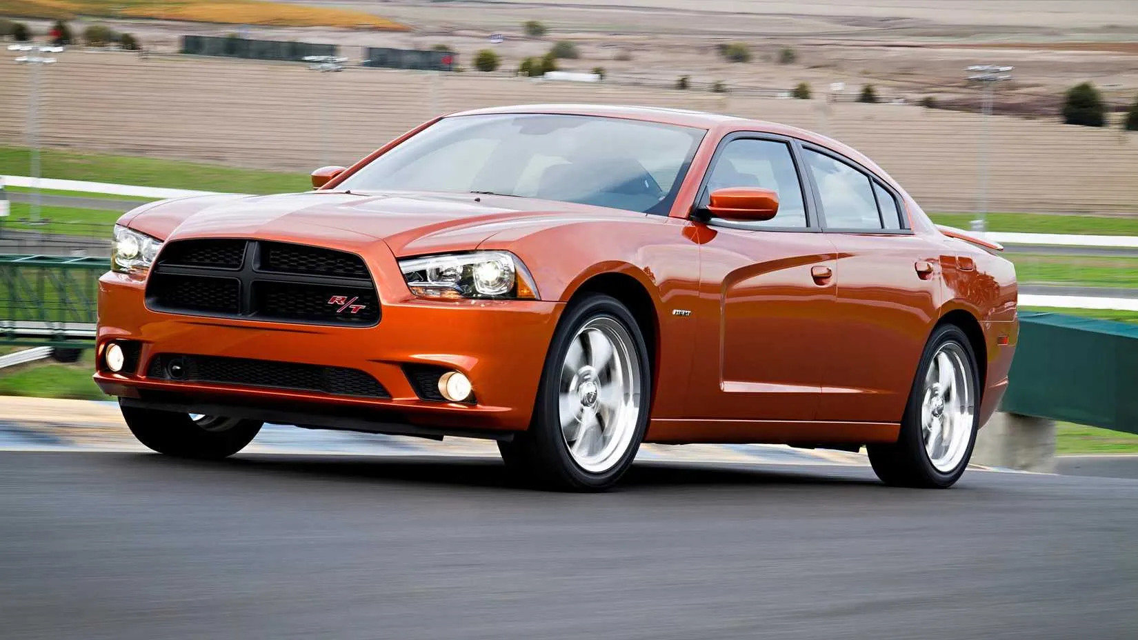 A 2014 Dodge Charger R/T in a bright blue color, showing its modern sedan silhouette