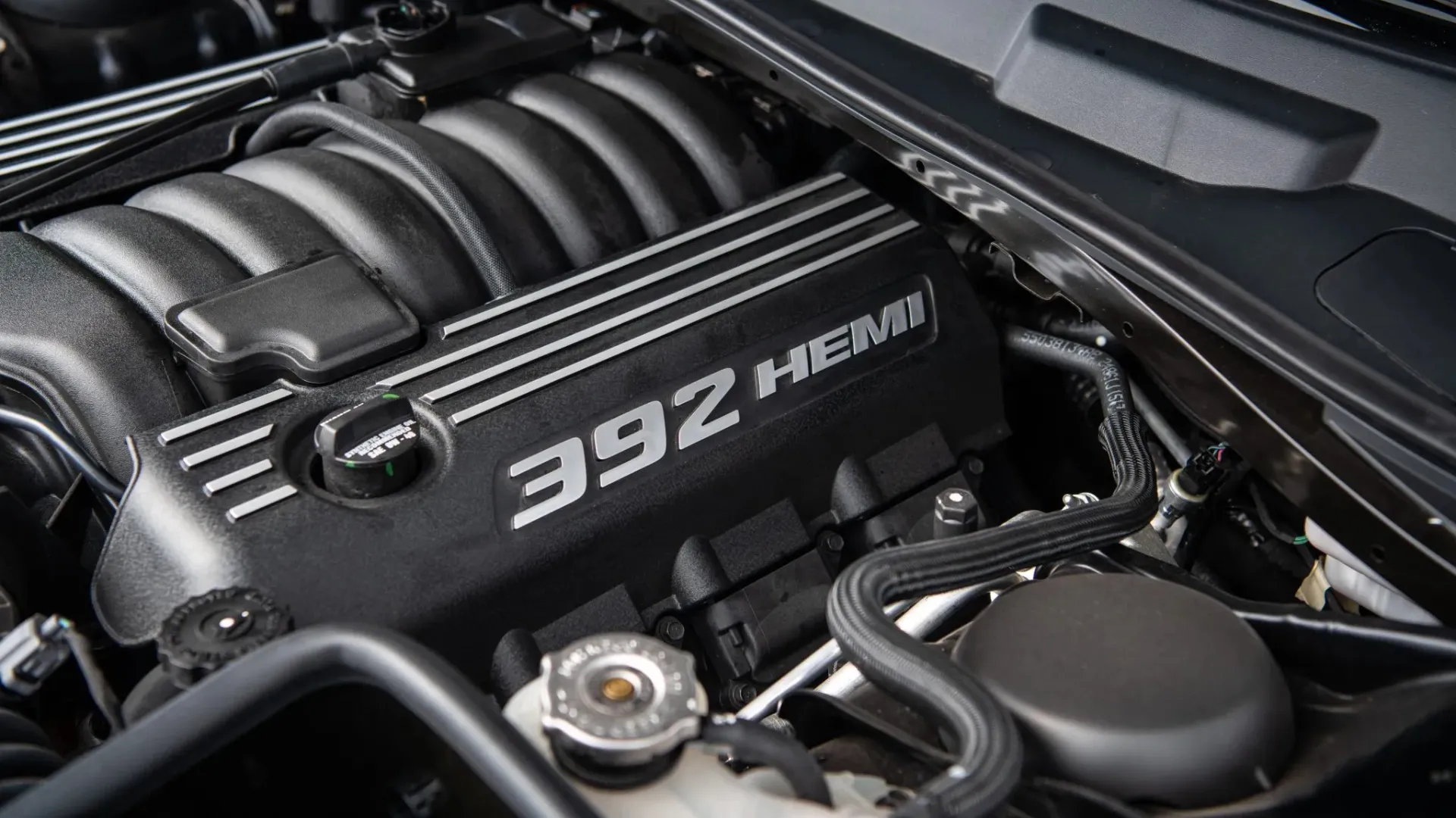 A sleek black 2013 Dodge Challenger SRT8 392 showing its aggressive front end and menacing stance.